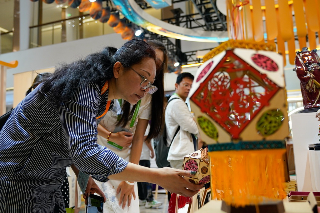 5月28日，参观者在国际非遗品牌IP授权交易活动上了解佛州花灯。