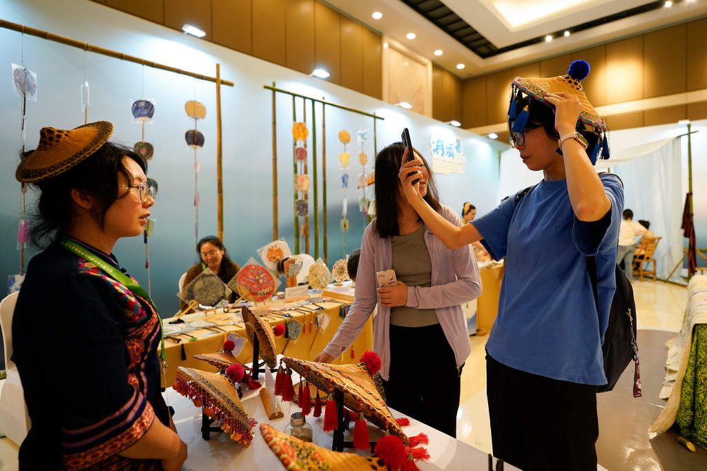 5月28日，在成都国际非遗节“魅力非遗·国际大展”现场，参观者体验毛南族花竹帽。