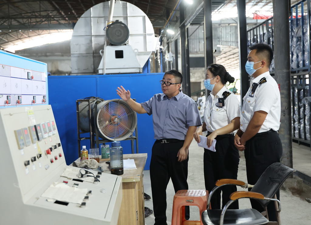 在海南乐东黎族自治县的海南象元实业有限公司，海口海关所属三亚海关关员（右一右二）了解企业生产情况（5月28日摄）。新华社记者 金皓原 摄