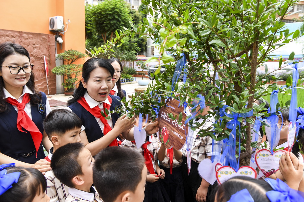 5月30日,在广西南宁市滨湖路小学教育集团滨湖校区少先队员入队仪式结束后,老师与新入队的少先队员们一起种下象征团结的石榴树,并在心愿卡上写下心愿与祝福。