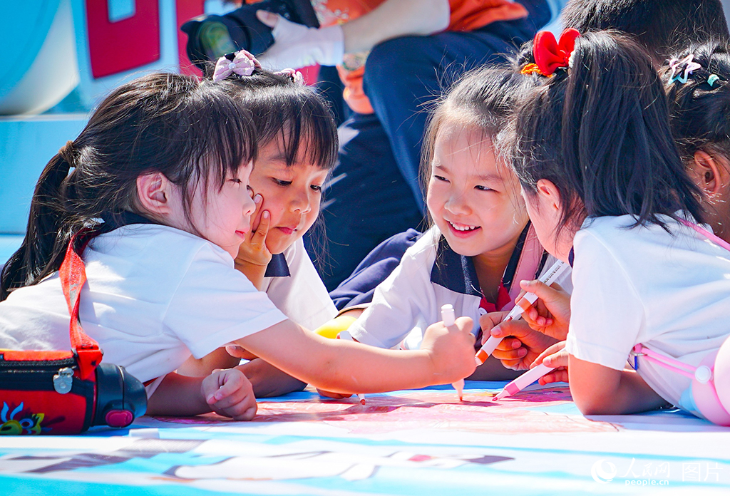 2025年5月27日，在黑龙江省哈尔滨极地公园，百名儿童在巨幅画布上挥洒童心，用五彩笔触描绘心目中的美丽世界。人民网记者 苏靖刚摄