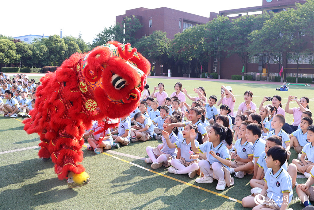 儿童节前夕，陕西省西安市第五保育院举办亲子运动会，孩子们与舞狮表演互动，现场一片欢声笑语。人民网记者 白鸽摄