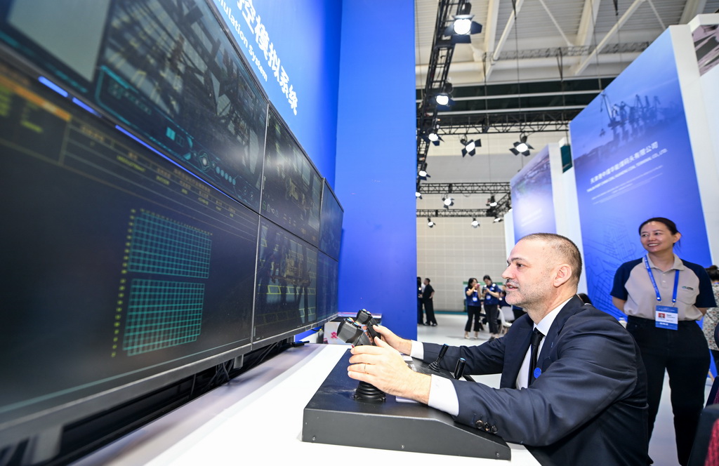 6月12日,与会者在博览会天津港展台体验码头远程操控模拟系统。新华社记者 赵子硕 摄