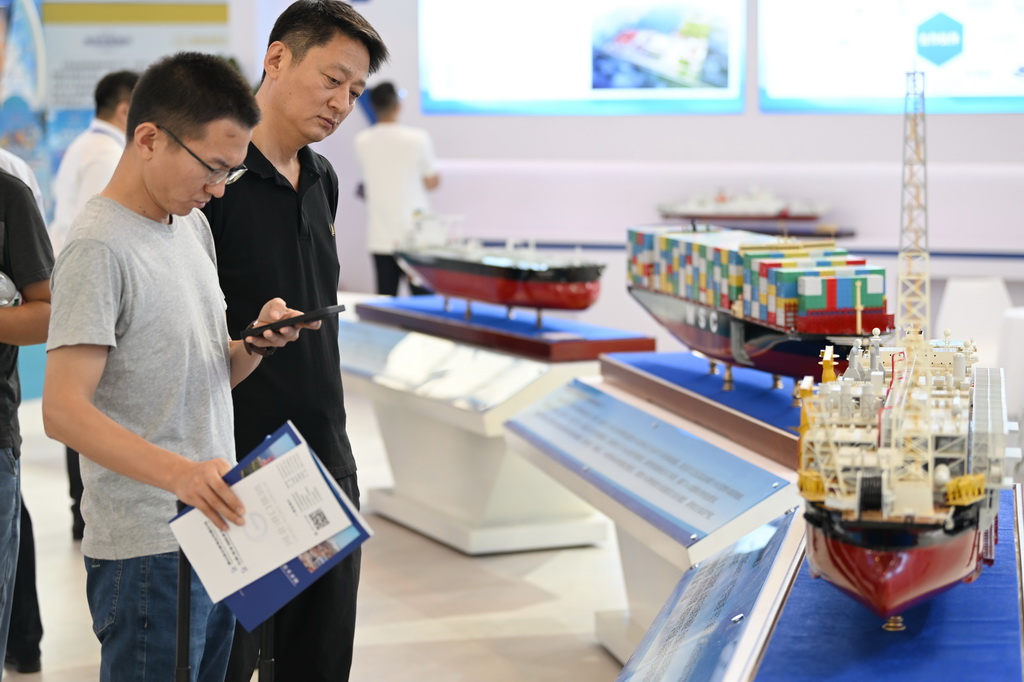 6月12日，与会者在博览会上参观轮船模型。新华社记者 李然 摄