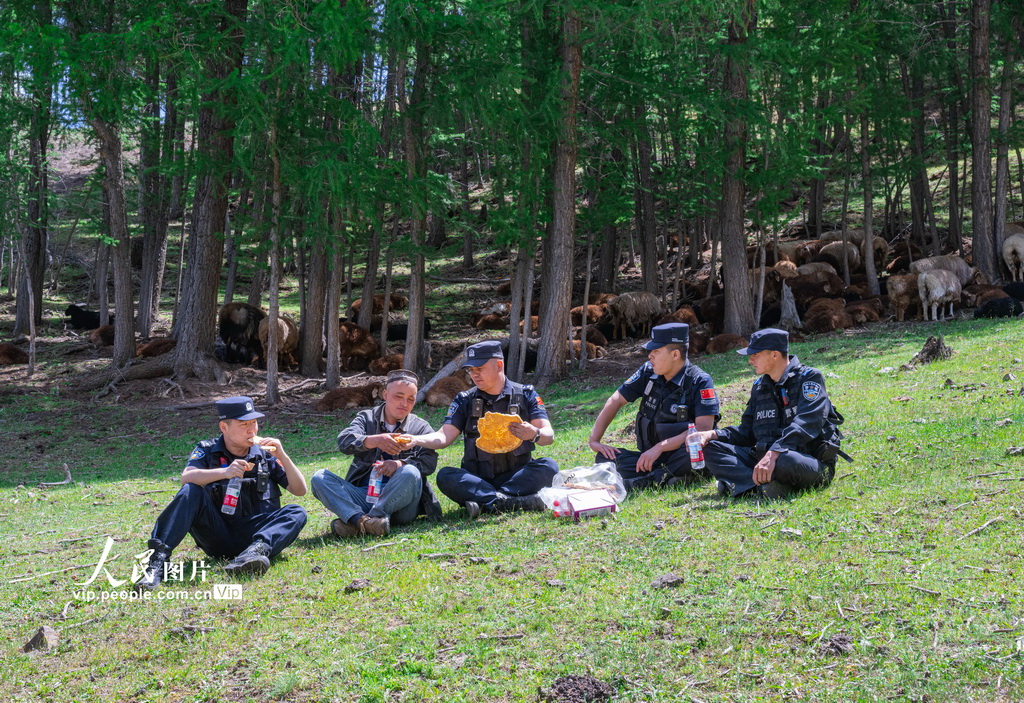 2025年6月13日，民警护和牧民在转场途中休息。