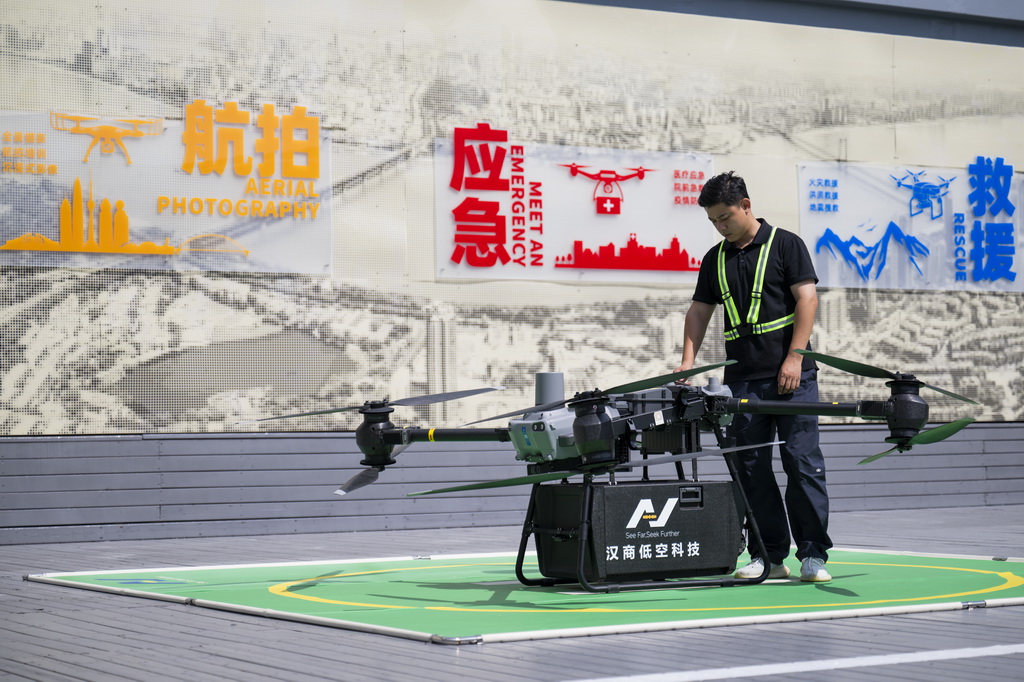 6月16日，在汉商低空港停机坪，一名工作人员在起飞前检查无人机工作状态。