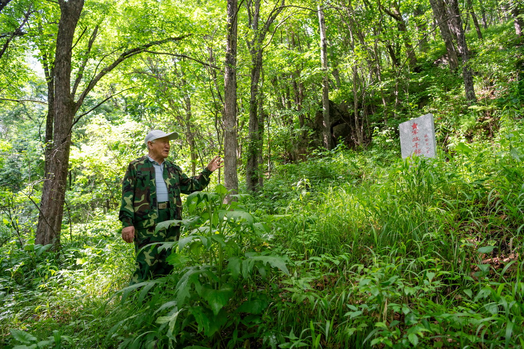 6月17日，在七星砬子抗联密营遗址内，集贤县革命老区建设促进会会长朴永鹤介绍抗联十一军军政干部学校遗址。