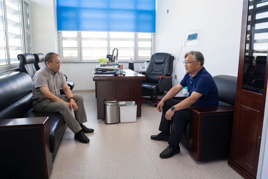 6月18日,在中国水稻研究所北方水稻研究中心,中心主任曹立勇(右)与浙江大学农业与生物技术学院教授徐海明交流寒地粳稻智能育种方面的合作。