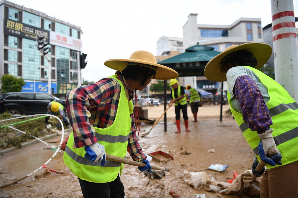 6月19日，环卫工人在广东省肇庆市怀集县城的一处十字路口清理街道。