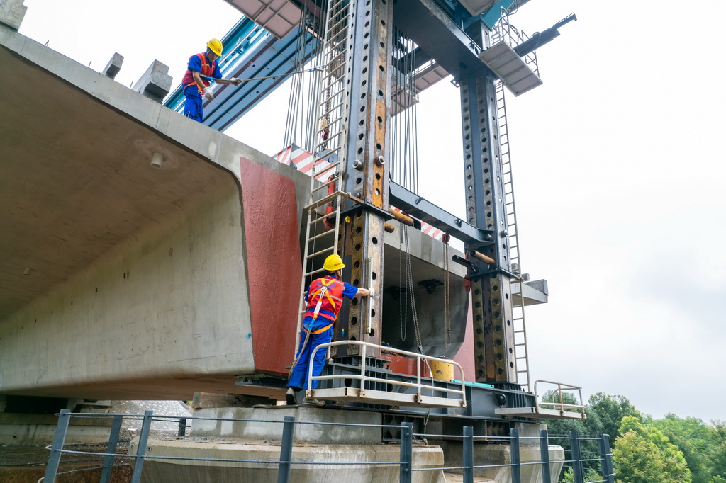 6月25日，在邵永高铁柘刺坪特大桥建设工地，中铁五局工人在进行架梁施工作业（无人机照片）。