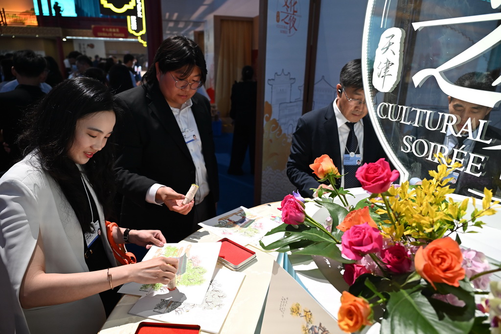 6月25日，在第十六届夏季达沃斯论坛文化之夜上，嘉宾体验杨柳青年画制作。新华社记者 隋尚君 摄