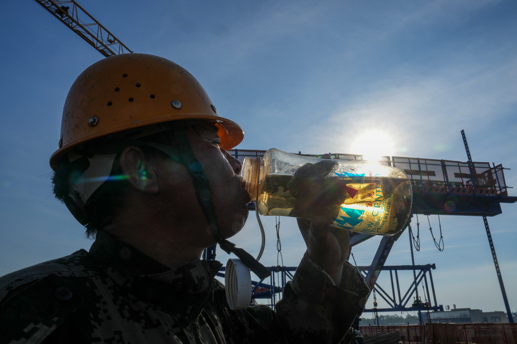 7月3日，中铁上海工程局的工人在宁淮城际铁路（南京至淮安）5标项目跨203县道连续梁施工现场喝水。