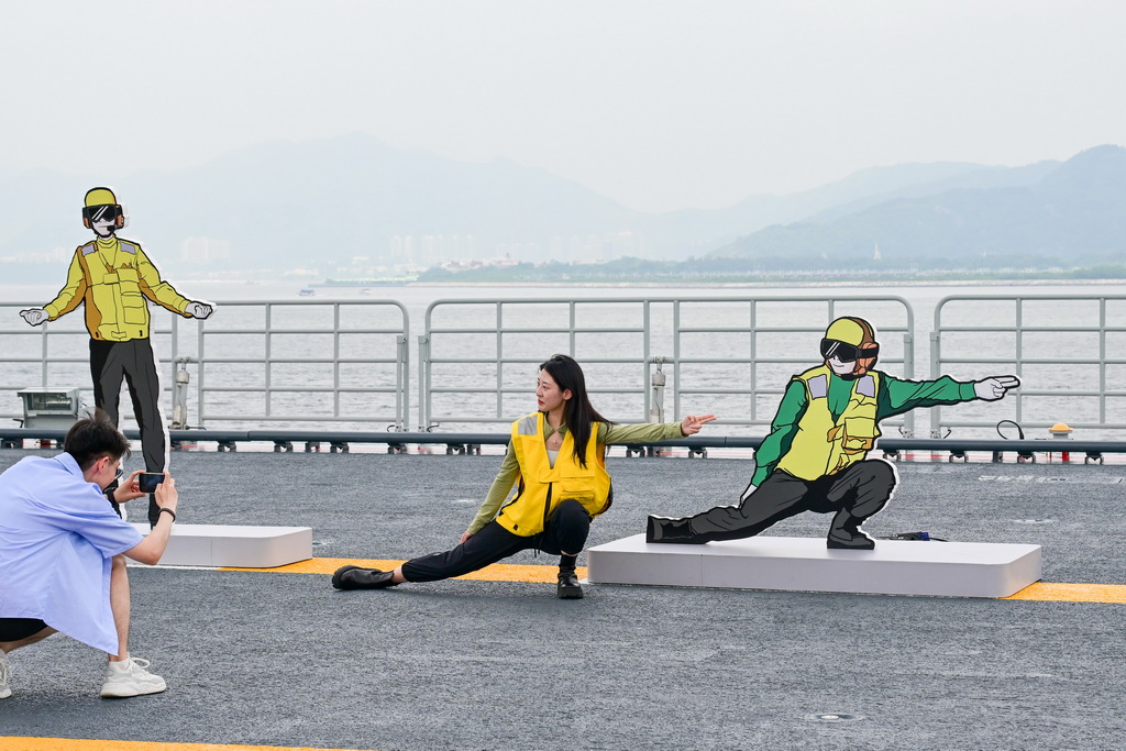 7月5日，民众在海军山东舰上留影纪念。