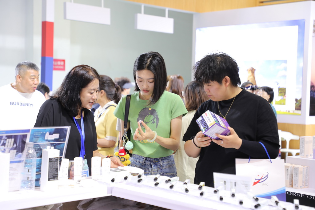 7月6日，一名韩国客商（前左一）在兰洽会上向参会嘉宾推介商品。