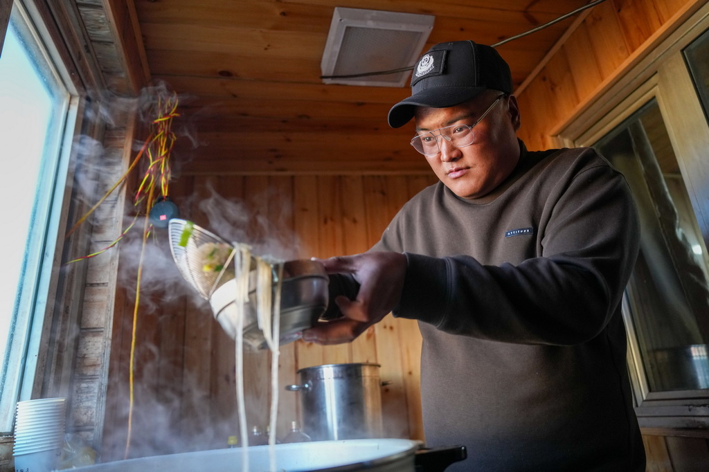 巡山队员在可可西里卓乃湖保护站做饭(7月3日摄)。