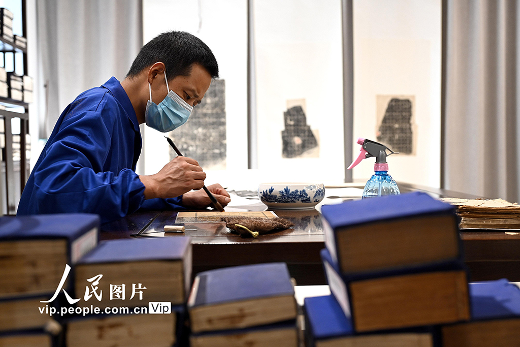 在河南省洛阳市图书馆古籍书库，工作人员对破损古籍进行修复。