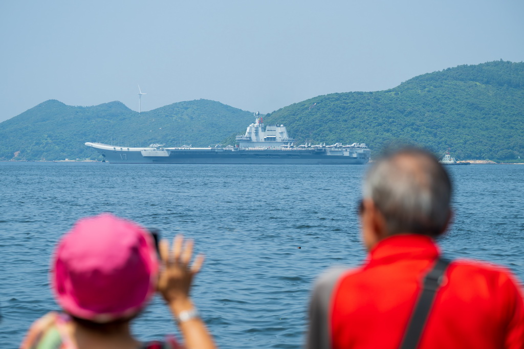7月7日,香港民众拍摄海军山东舰航母编队离开香港。新华社记者 朱炜 摄