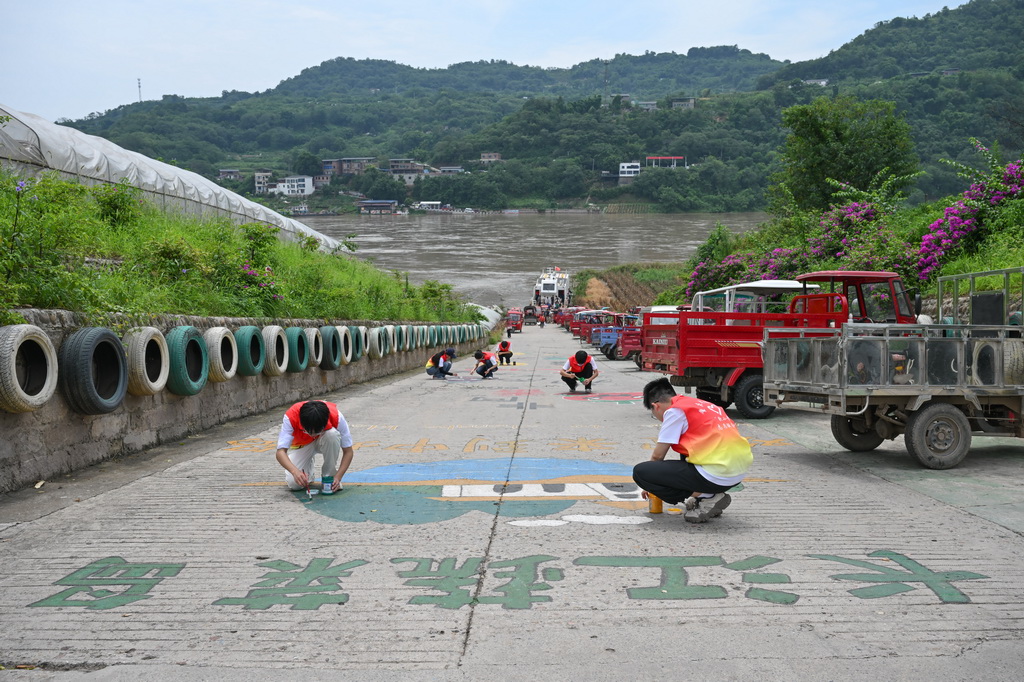  7月7日，志愿者在巴南区中坝岛绘制创意图案。
