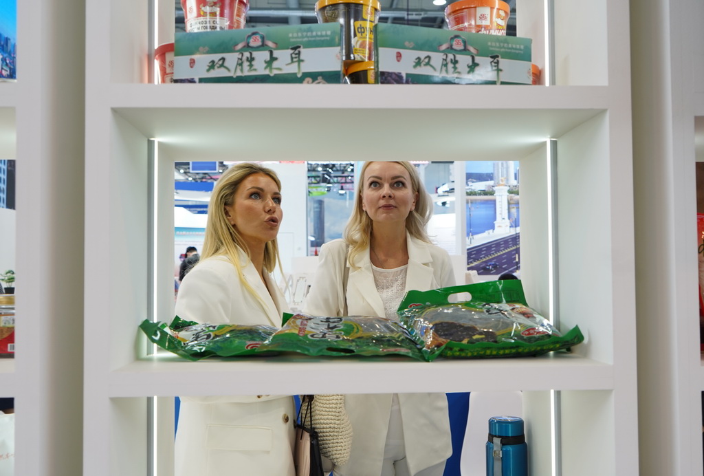 7月7日，在俄罗斯斯维尔德洛夫斯克州首府叶卡捷琳堡国际展览中心，参展者在第九届中俄博览会现场了解中国农副产品。新华社记者 刘恺 摄