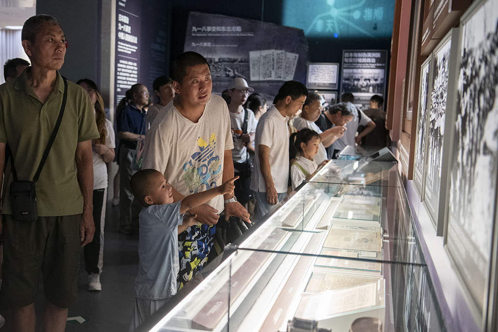 2025年7月8日，在中国人民抗日战争纪念馆，一位家长带着孩子参观抗战胜利80周年主题展。