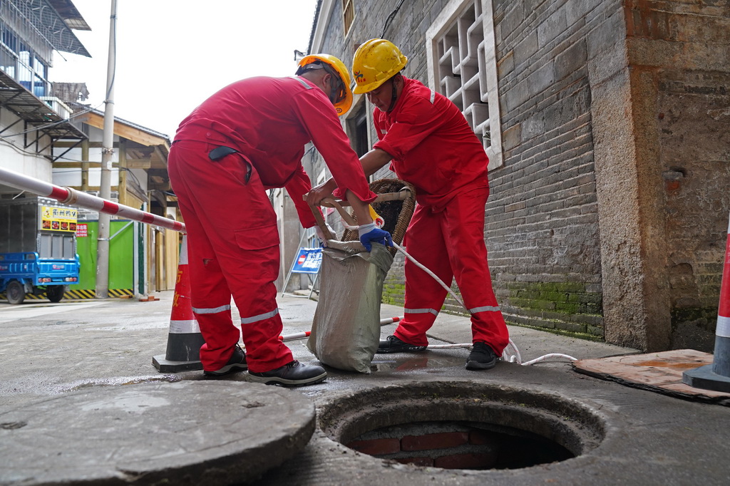 在赣州古城一条街巷，市政工作人员在对福寿沟管网进行清疏（6月18日摄）。
