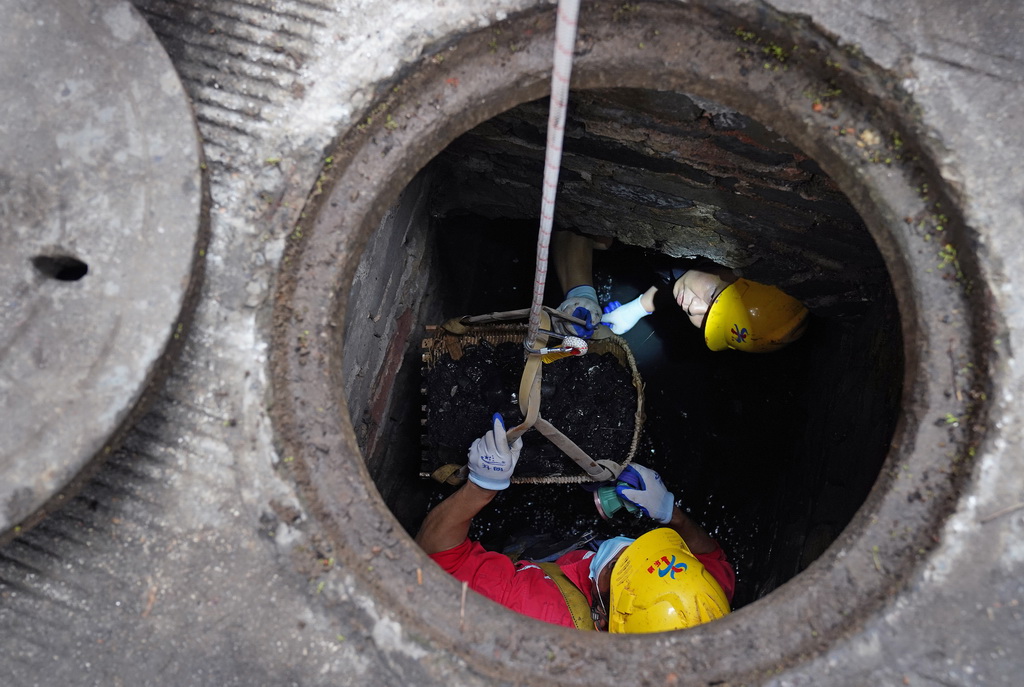 在赣州古城一条街巷，市政工作人员在对福寿沟管网进行清疏（6月18日摄）。