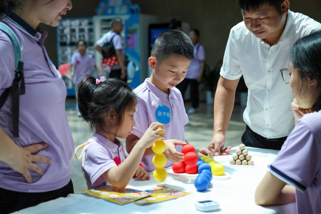 7月8日，参加夏令营的“小候鸟”在深圳中国钢结构博物馆里参与互动游戏。