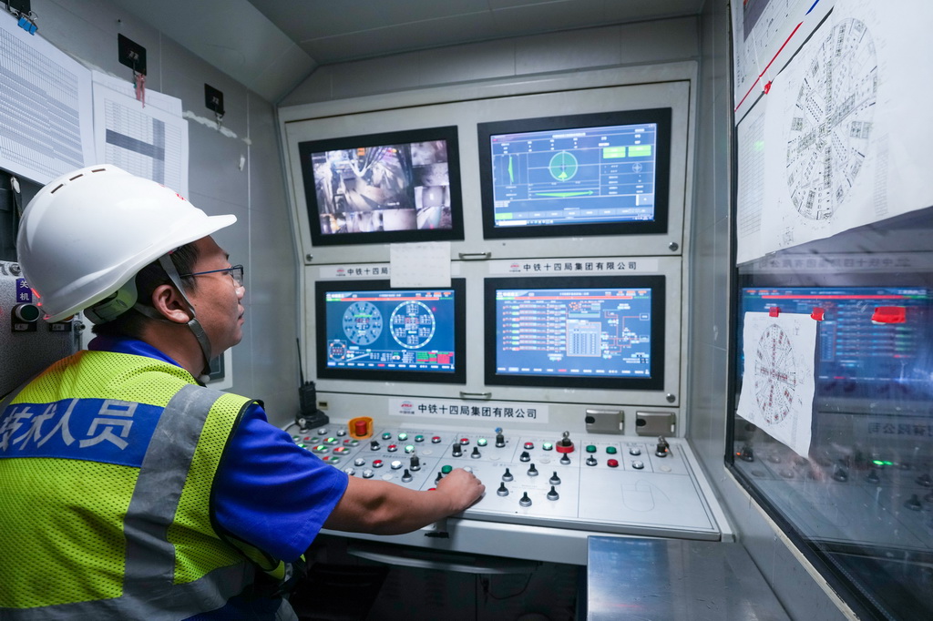 7月9日,中铁十四局的施工人员在施工现场查看盾构机作业情况。