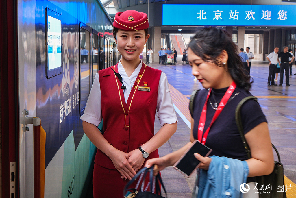 7月9日,乘务员迎接旅客乘车。