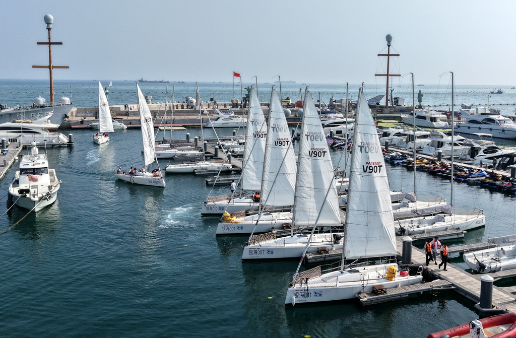 市民和游客在青岛银海大世界港池乘船参加海上巡游活动（7月10日摄，无人机照片）。