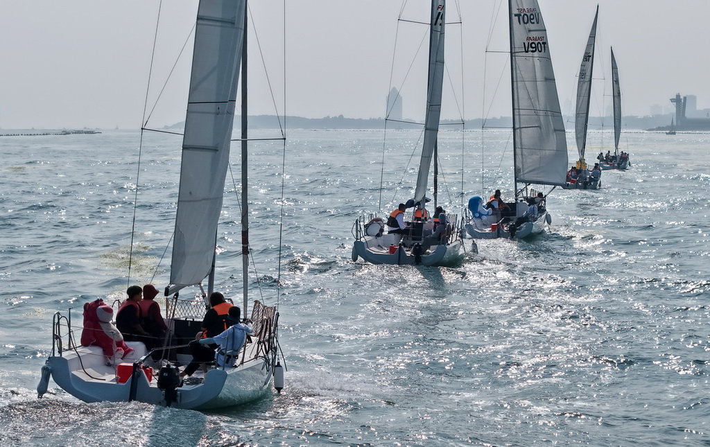 青岛老龙湾海域，市民和游客乘船参加海上巡游活动（7月10日摄，无人机照片）。