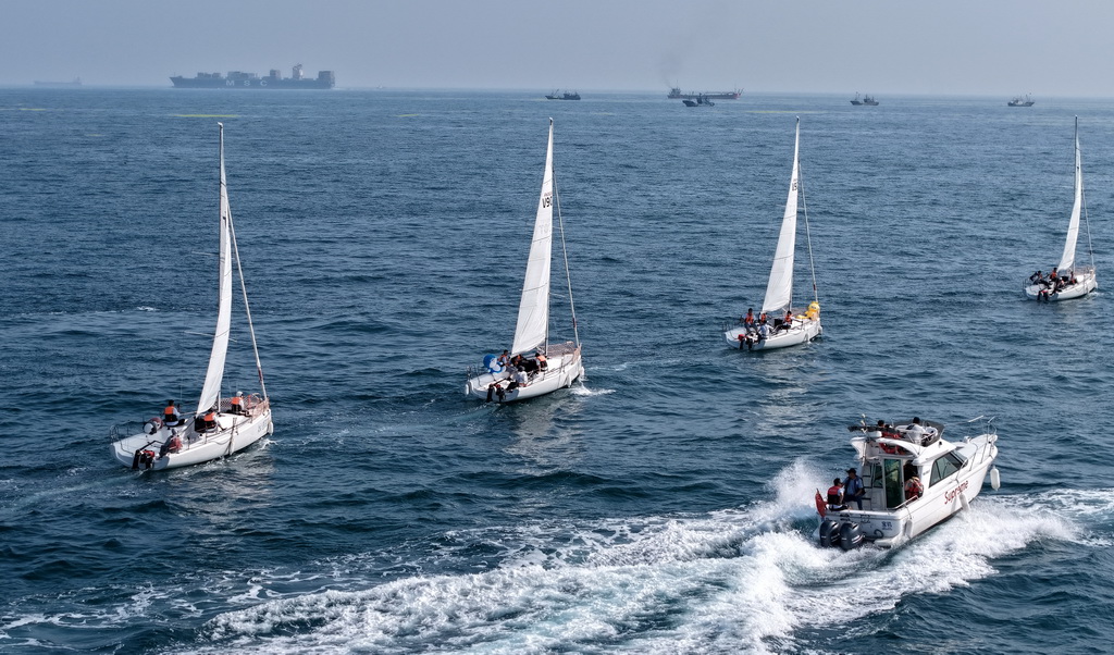 青岛老龙湾海域，市民和游客乘船参加海上巡游活动（7月10日摄，无人机照片）。
