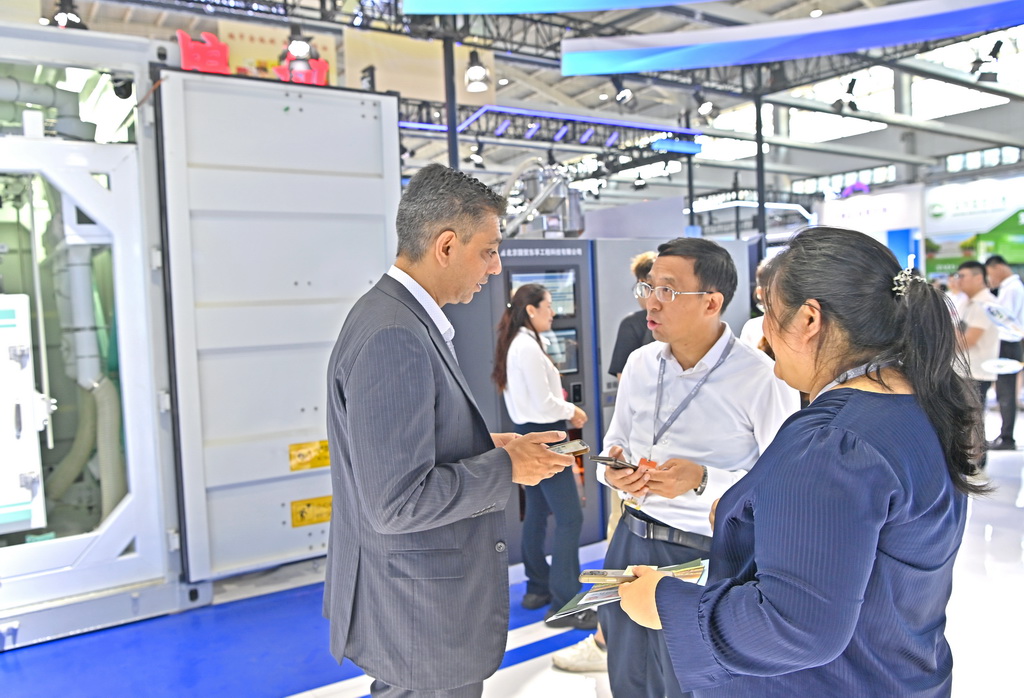 7月12日，国外客商在沈阳国际展览中心了解粮食加工机械。