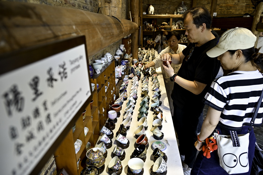 7月13日，在江西省景德镇市陶阳里历史文化街区，游客选购手工陶瓷制品。
