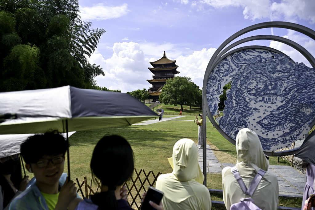 7月13日，游客在江西省景德镇市陶阳里历史文化街区一处网红打卡点排队留影。