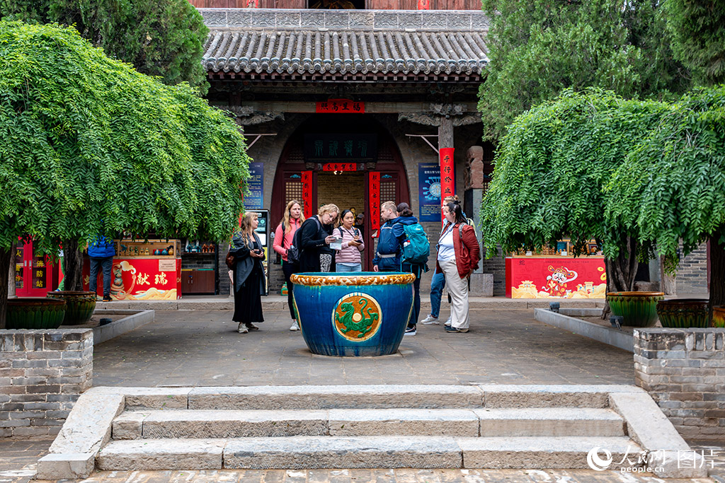 2025年5月23日，外国游客在山西介休张壁古堡景区参观游览，感受中国传统古建风貌。人民网 马梦迪摄