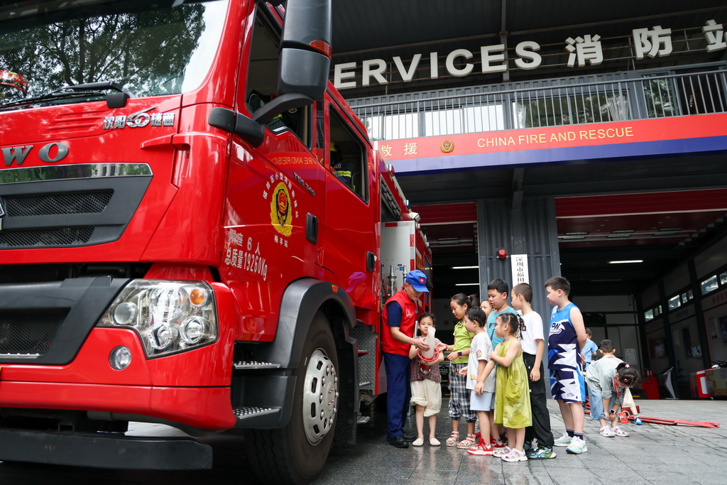 7月15日，站长孙航（左一）在深圳市福田区梅丰小型消防站开放日活动上为小朋友科普消防知识。