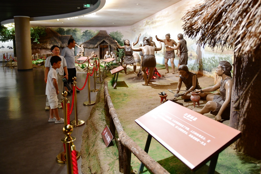 7月14日，游客在大汶口遗址博物馆内参观先民生活场景复原模型。