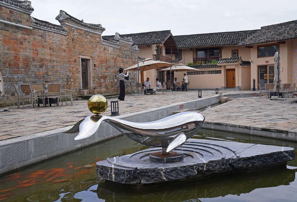 游客在龙南市关西镇的田心围民宿院子里休息（6月19日摄）。