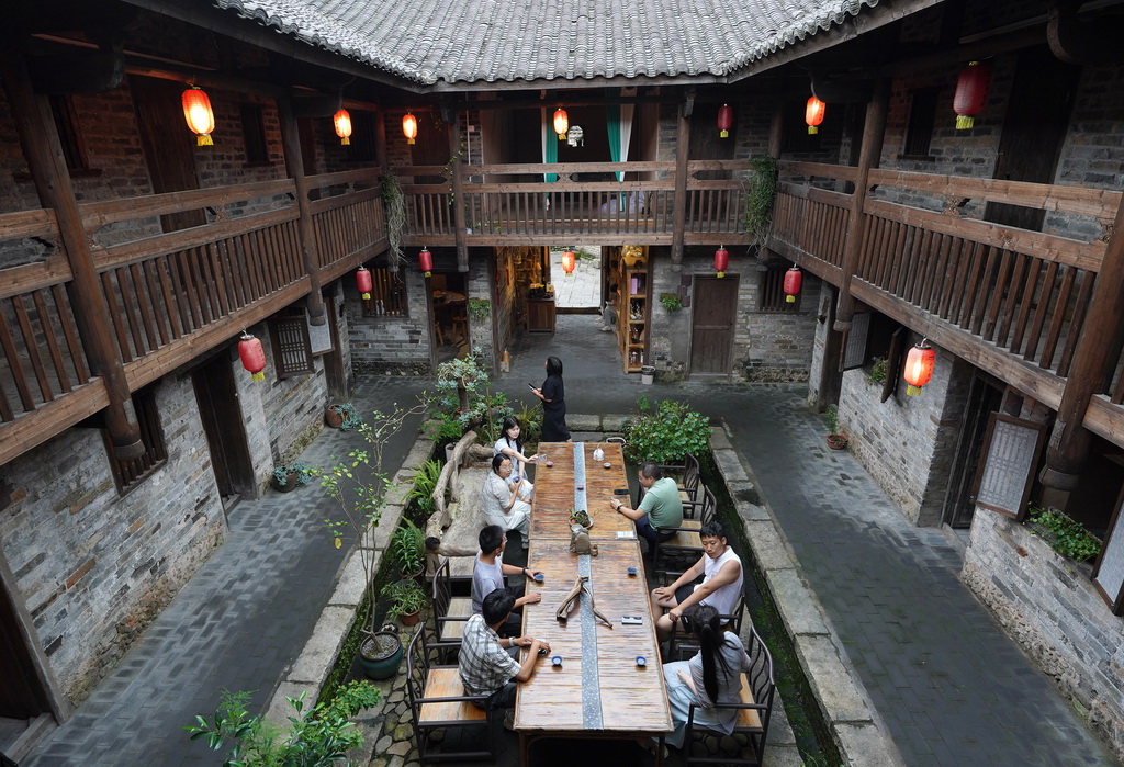 游客在龙南市杨村镇的细翼围内品茶交谈（6月19日摄）。