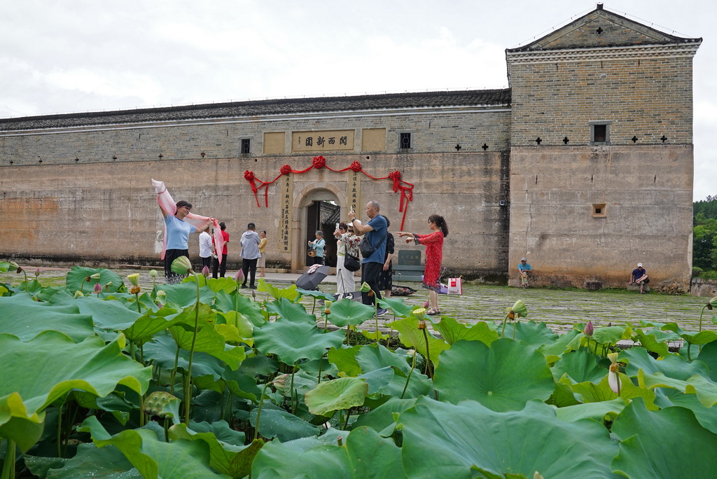 游客在龙南市关西镇关西新围前游览观光（6月19日摄）。