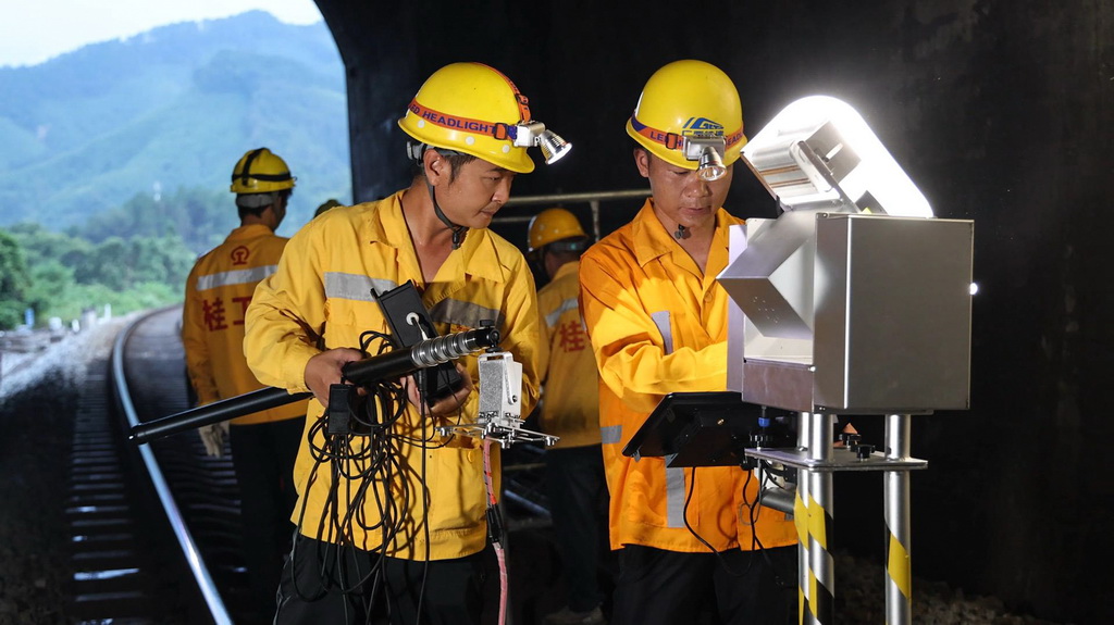 桥隧工人检查隧道内铁轨（7月16日摄）。