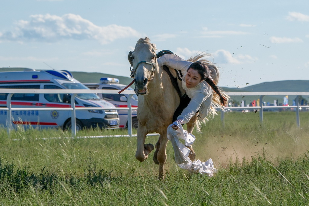 7月20日，选手在骑马拾哈达比赛中。