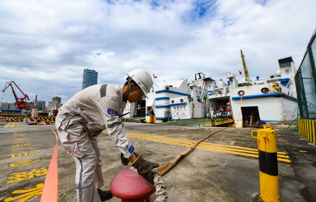 7月22日，在海口市秀英港，工作人员为刚靠泊的客滚船固定缆绳。
