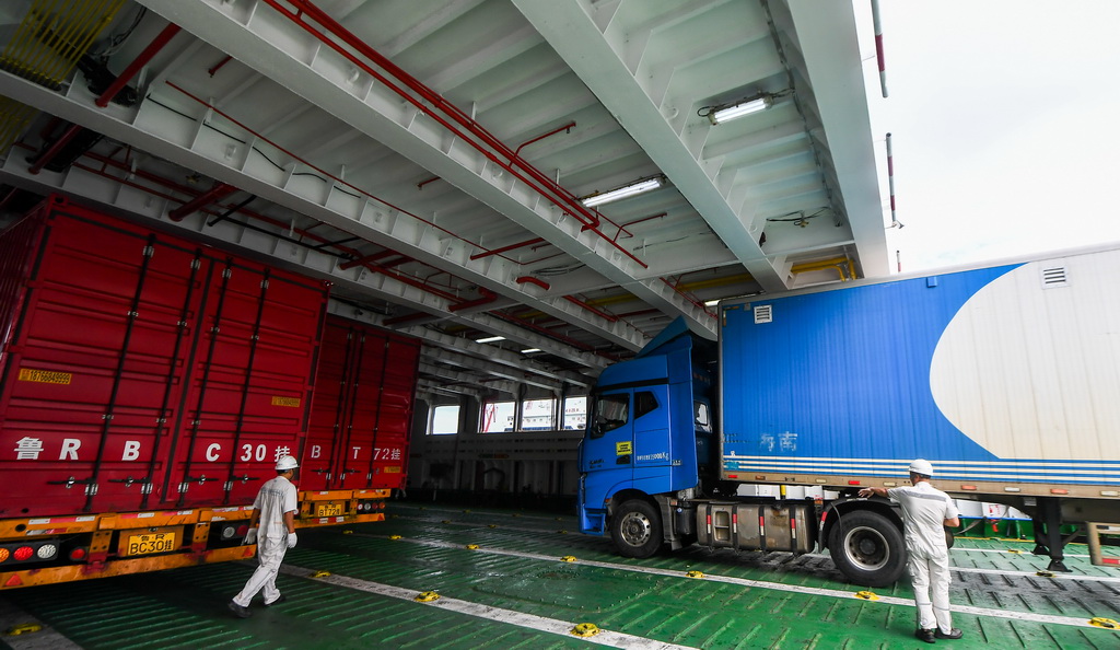 7月22日，在海口市秀英港，货车在工作人员指挥下驶入客滚船。