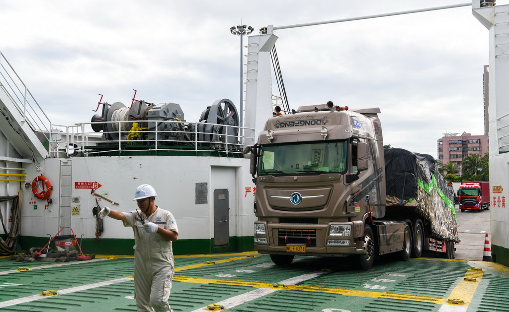 7月22日，在海口市秀英港，货车在工作人员指挥下驶入客滚船。