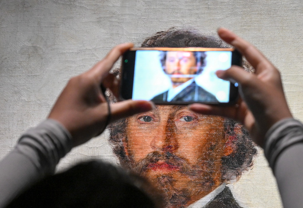 7月22日，一名记者拍摄列宾《自画像》。