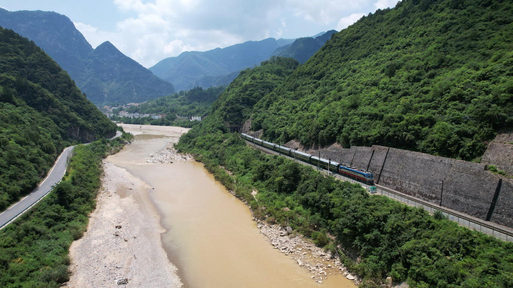 7月15日，一列火车行驶在嘉陵江畔的宝成铁路上（无人机照片）。新华社记者 陈斌 摄