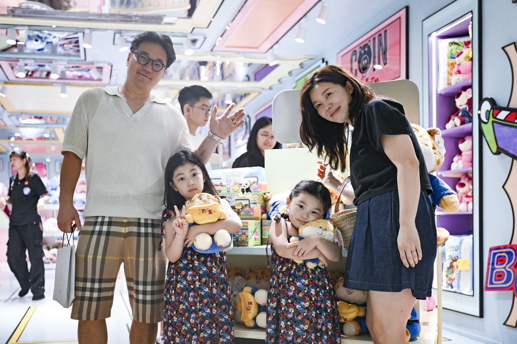 7月17日,韩国游客在位于上海市南京路步行街的一家潮玩店里购物。新华社记者 唐斯琦 摄