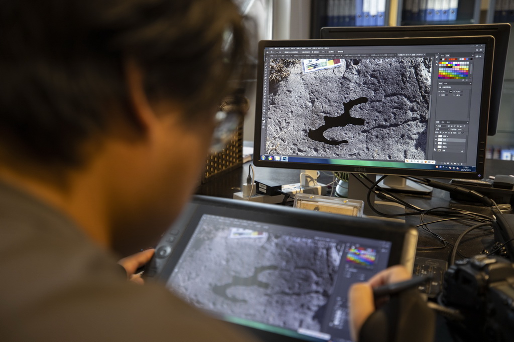 7月23日，工作人员在绘制岩画电子线描图。在岩画普查工作中，岩画电子线描图是实景岩画图像数字化的一种辅助方式，使画面清晰明确地呈现在岩画信息资料库中，便于日后查阅与研究工作。